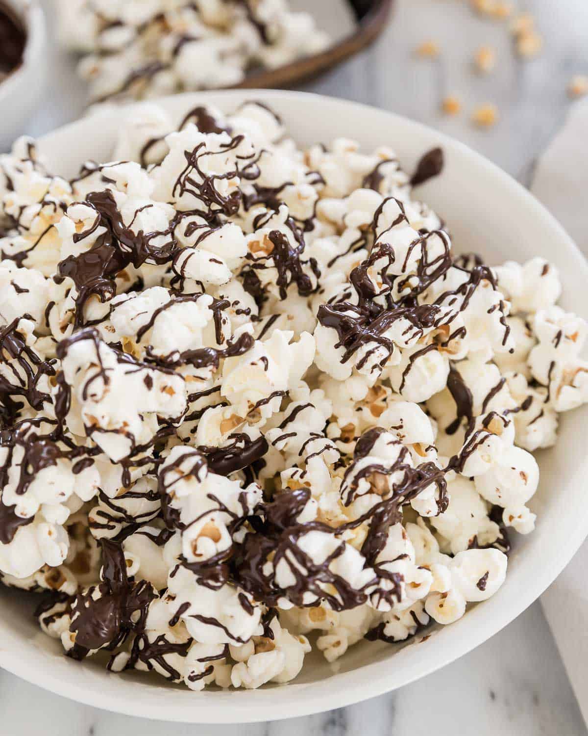 Chocolate covered popcorn in a white bowl.