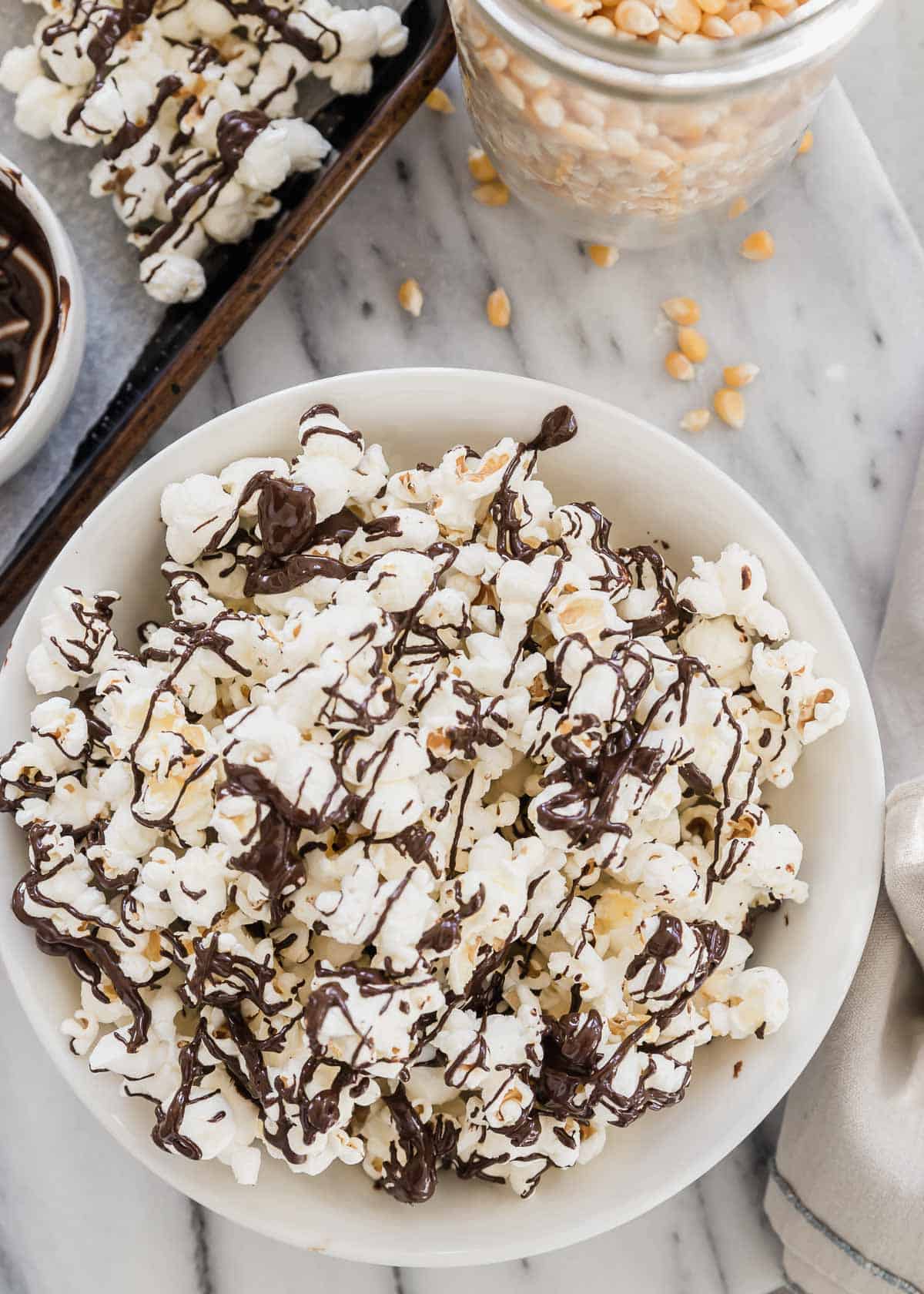 A bowl of popcorn with chocolate drizzle.