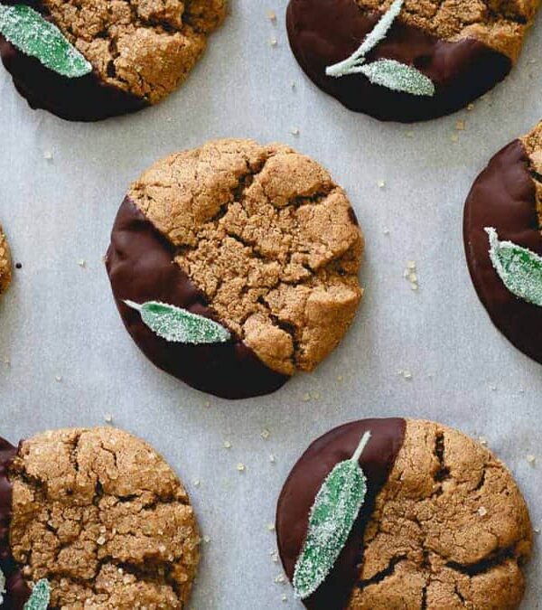 Chocolate sage cookies with sage leaves on a baking sheet.
