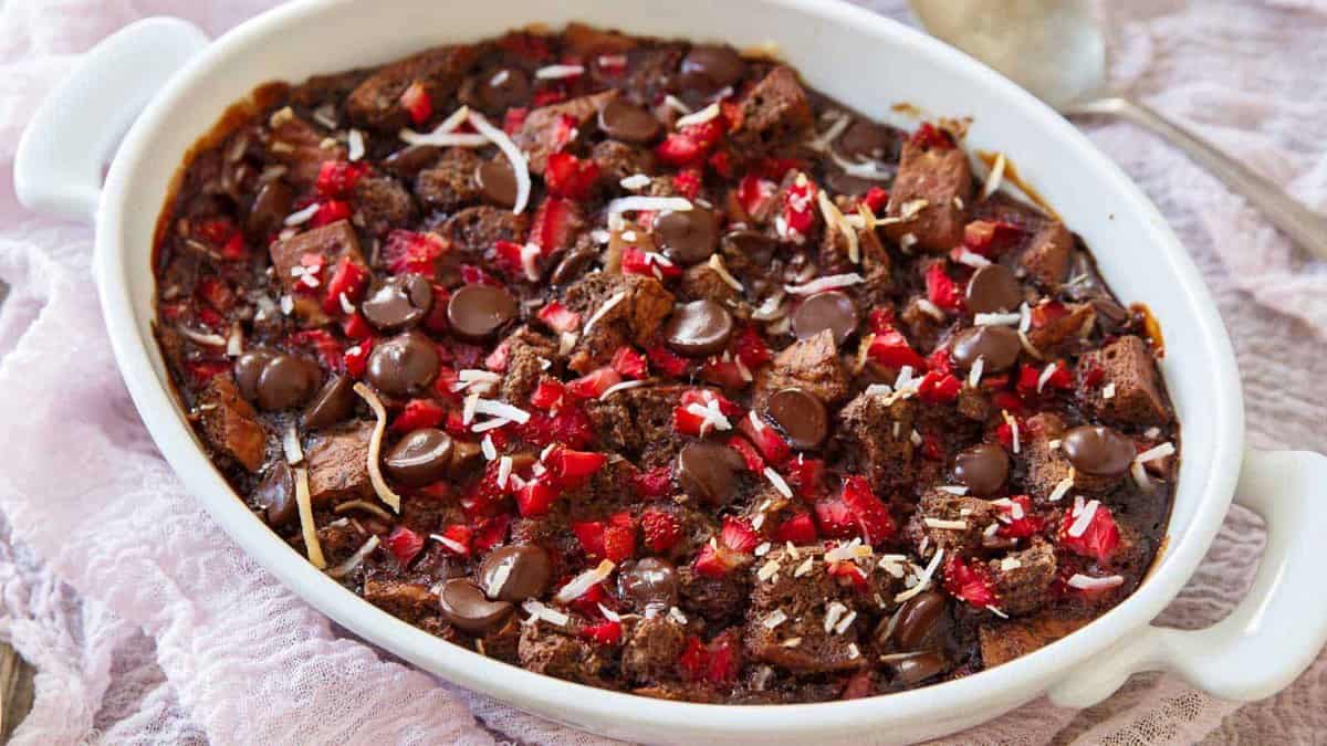 Strawberry chocolate chip bread pudding in a white baking dish.