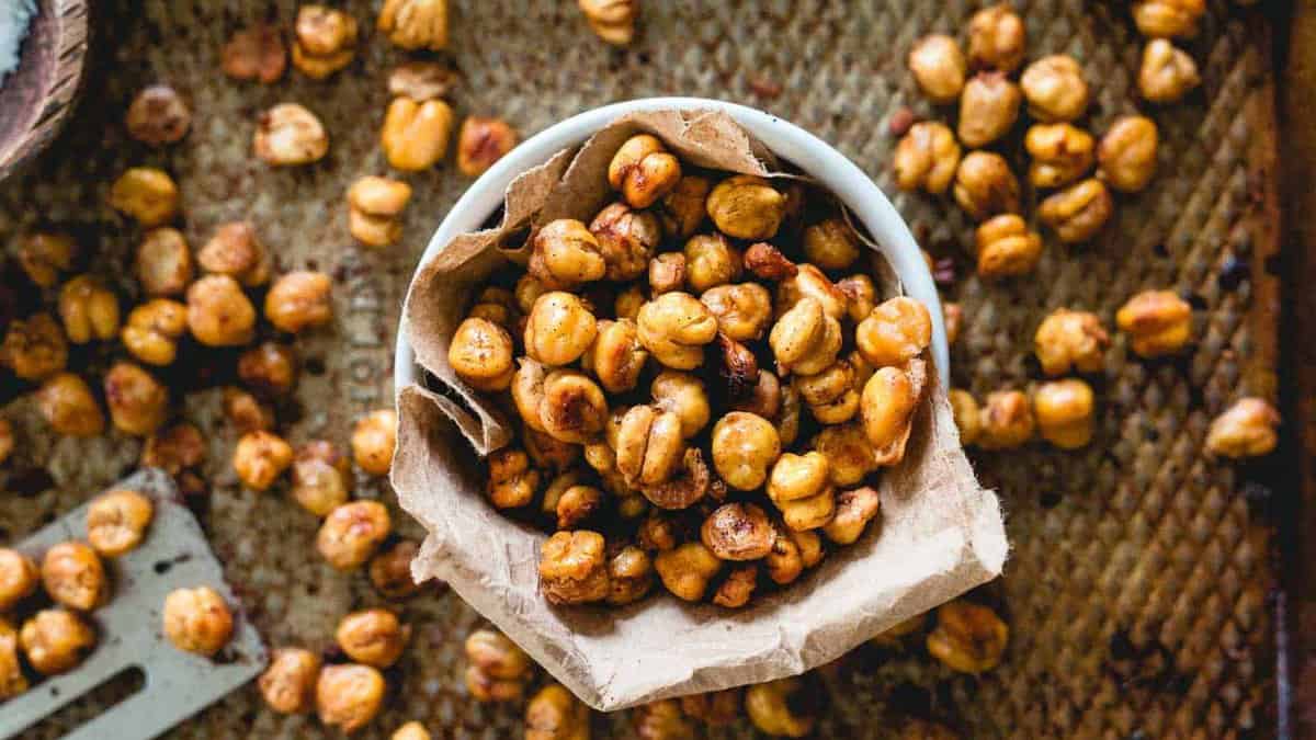 Cinnamon crunch roasted chickpeas in a bowl with more scattered around.