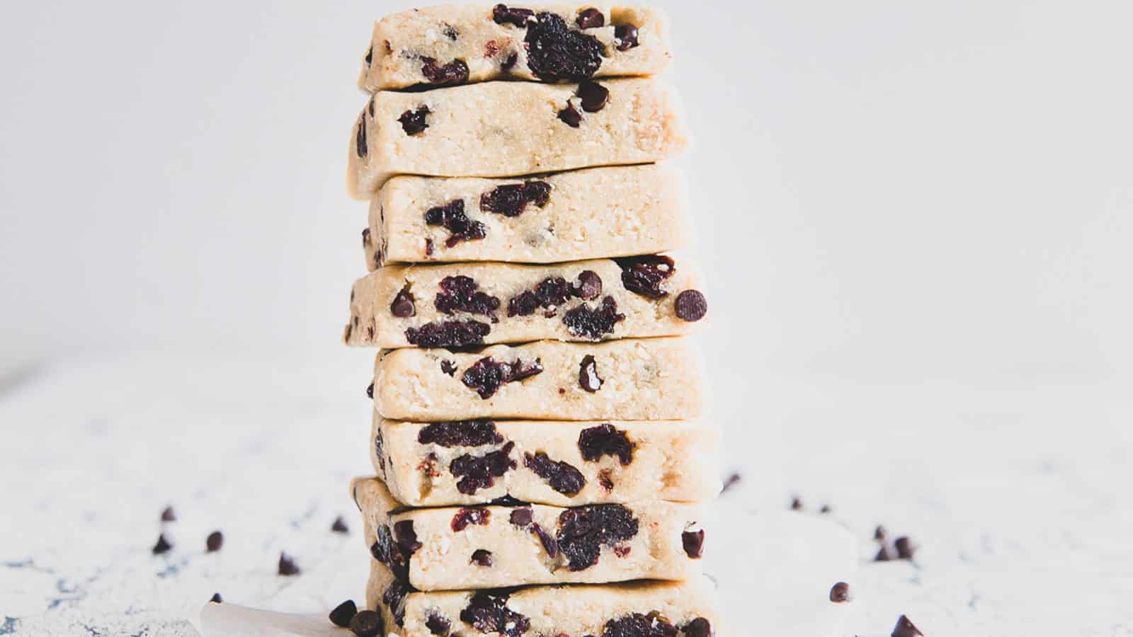Healthy cookie dough bars stacked high on parchment paper.