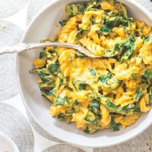 A bowl of pasta with spinach in it.