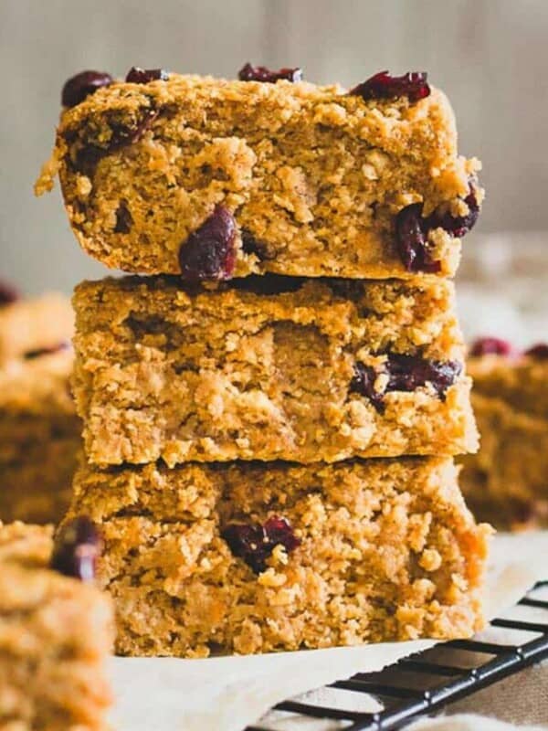 A stack of oatmeal bars with cranberries on top.