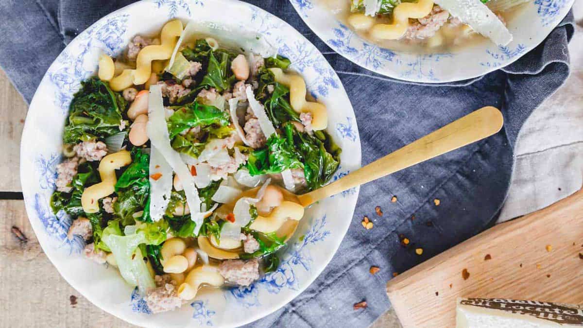 Escarole soup with pasta and sausage in a bowl.