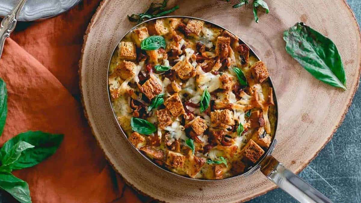 Everything bagel strata in metal baking dish on wooden surface.