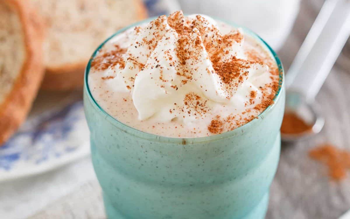 French toast smoothie in a blue green glass with cinnamon dusting.