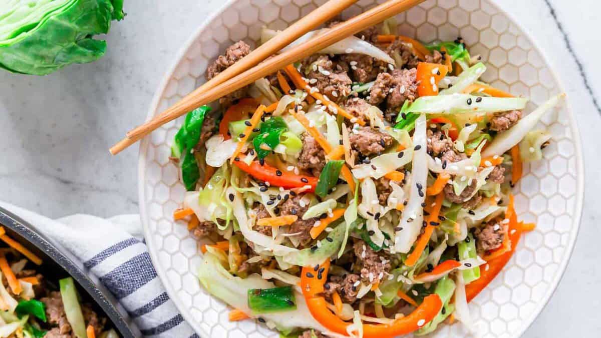 Ground beef cabbage stir fry in a bowl with chopsticks.