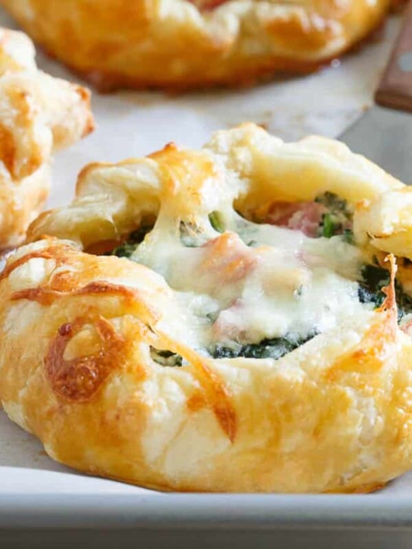 A tray of pastries with cheese and spinach on it.