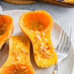 Roasted honey patch squash with miso butter on a plate with a fork.