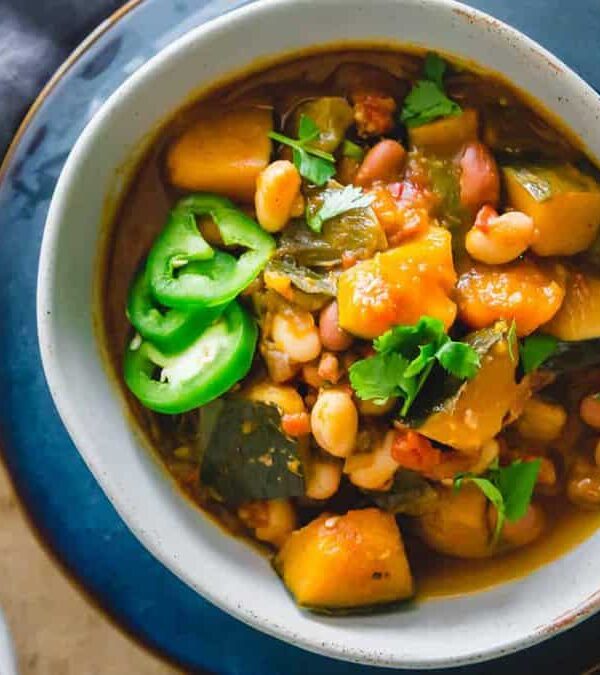 Two bowls of bean and squash stew on a table.
