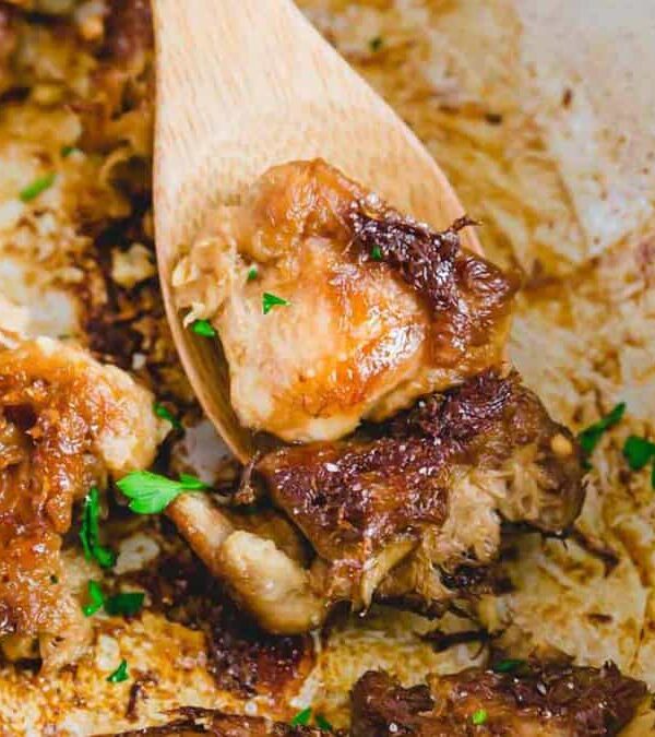 Lion's mane mushrooms in a skillet with a wooden spoon.