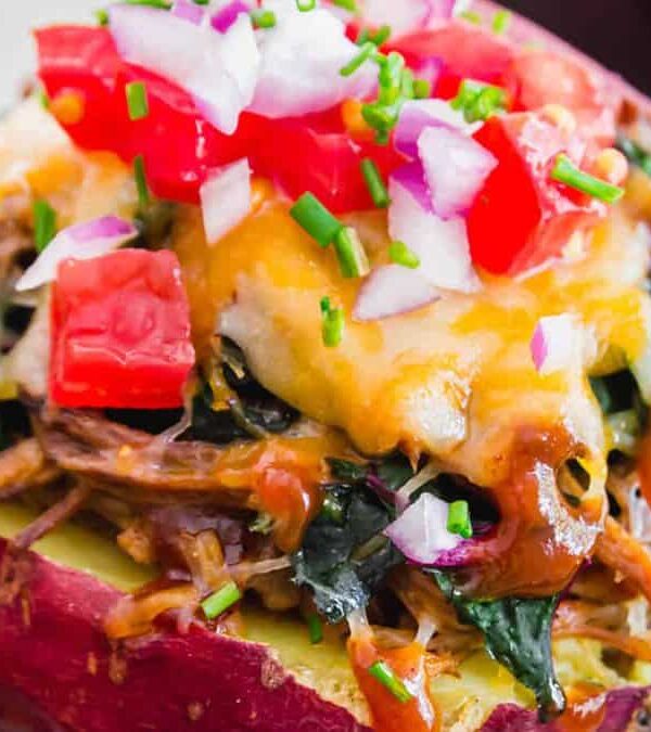 Stuffed sweet potatoes topped with cheese and toppings.