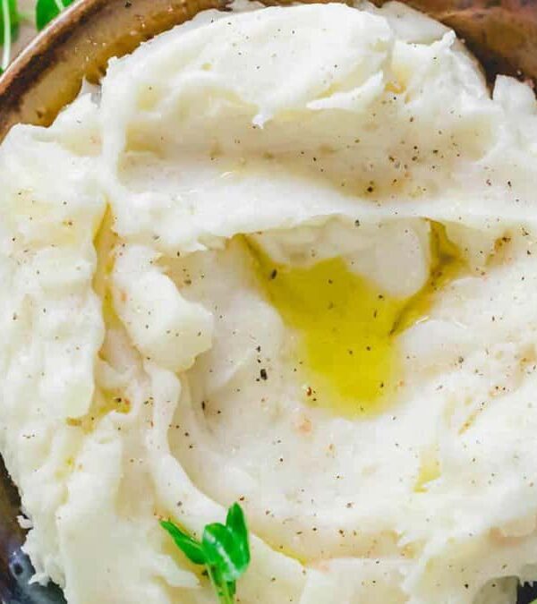Mashed potatoes in a bowl with sprigs of thyme.