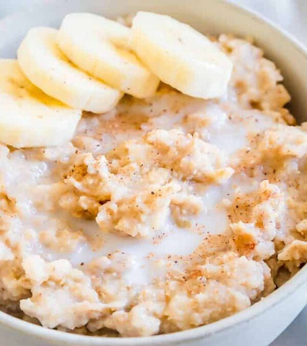 Millet porridge in a bowl with a spoon and banana slices.