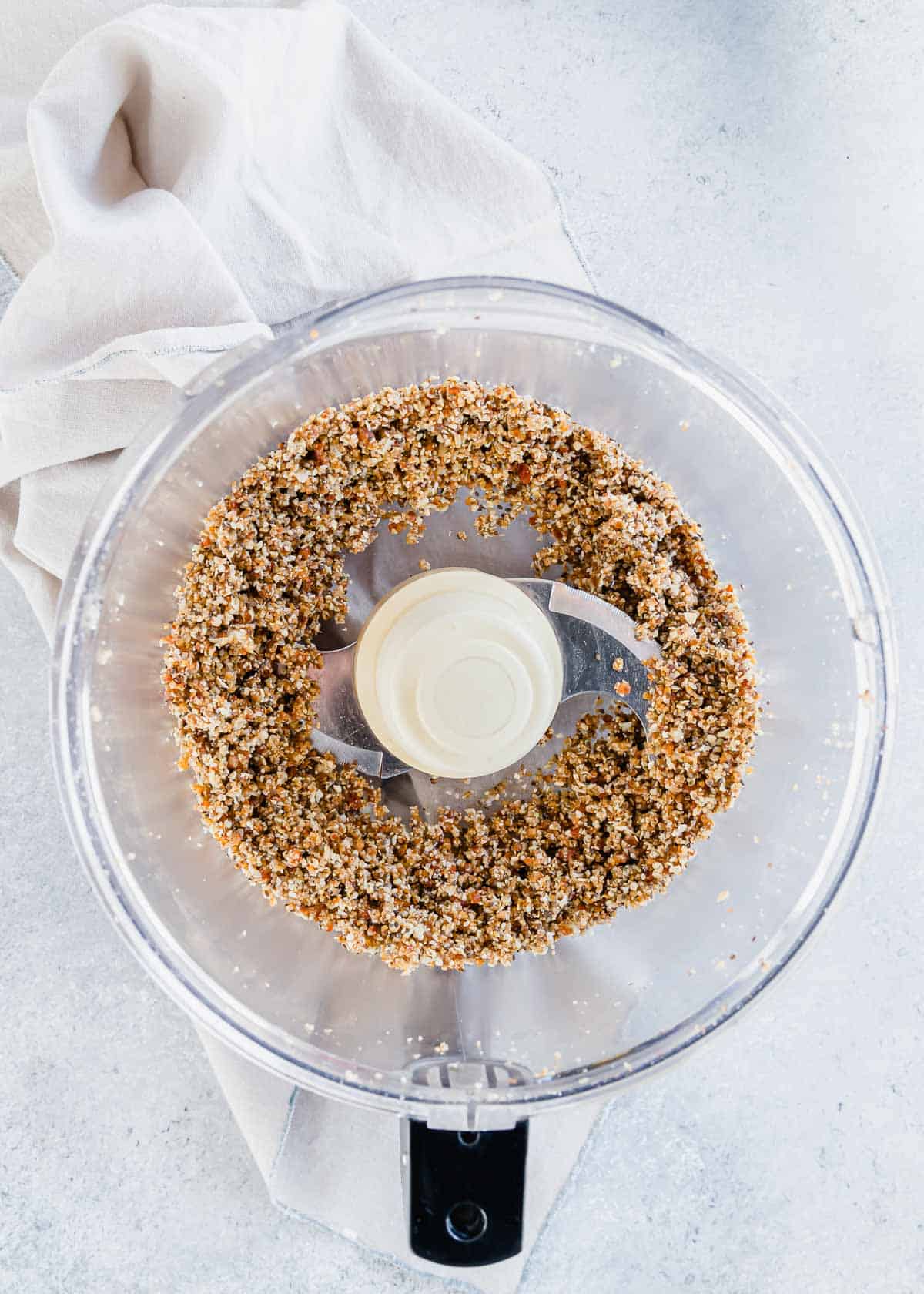 Food processor bowl with processed ingredients to make energy balls.