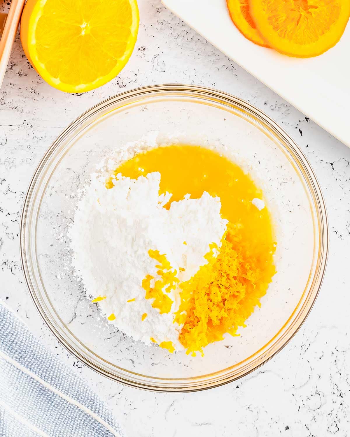 Making the glaze for orange muffins in a glass bowl.