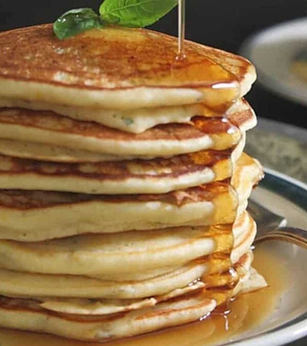 A stack of pancakes with syrup on a plate.