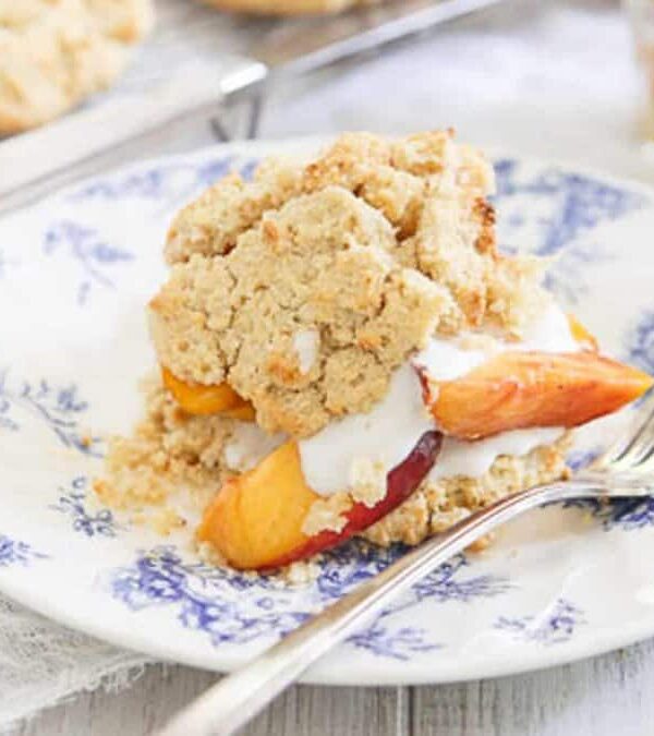 Peach shortcake on a plate with a fork.