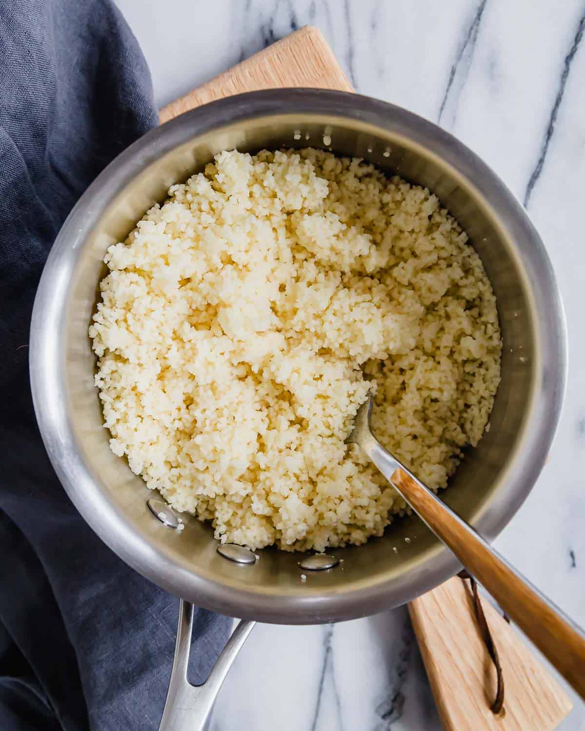 Couscous in a pan fluffed with a fork.