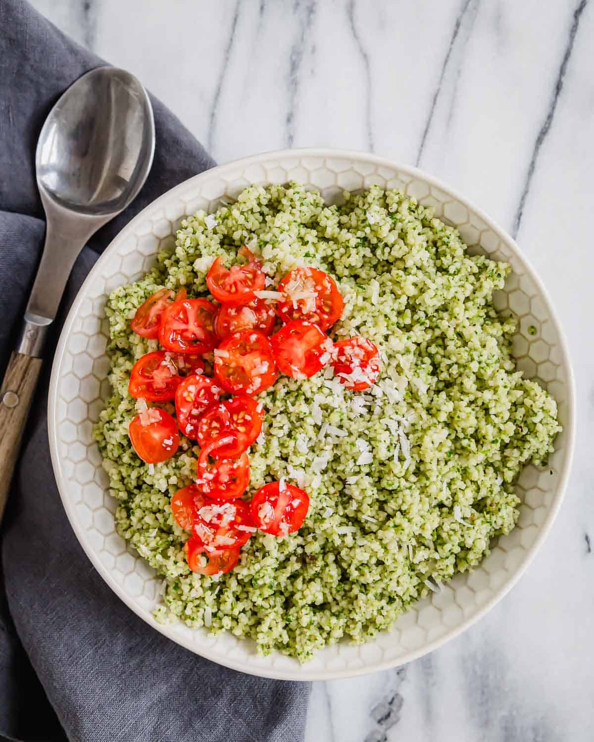 Pesto couscous with tomatoes and fresh parmesan cheese.