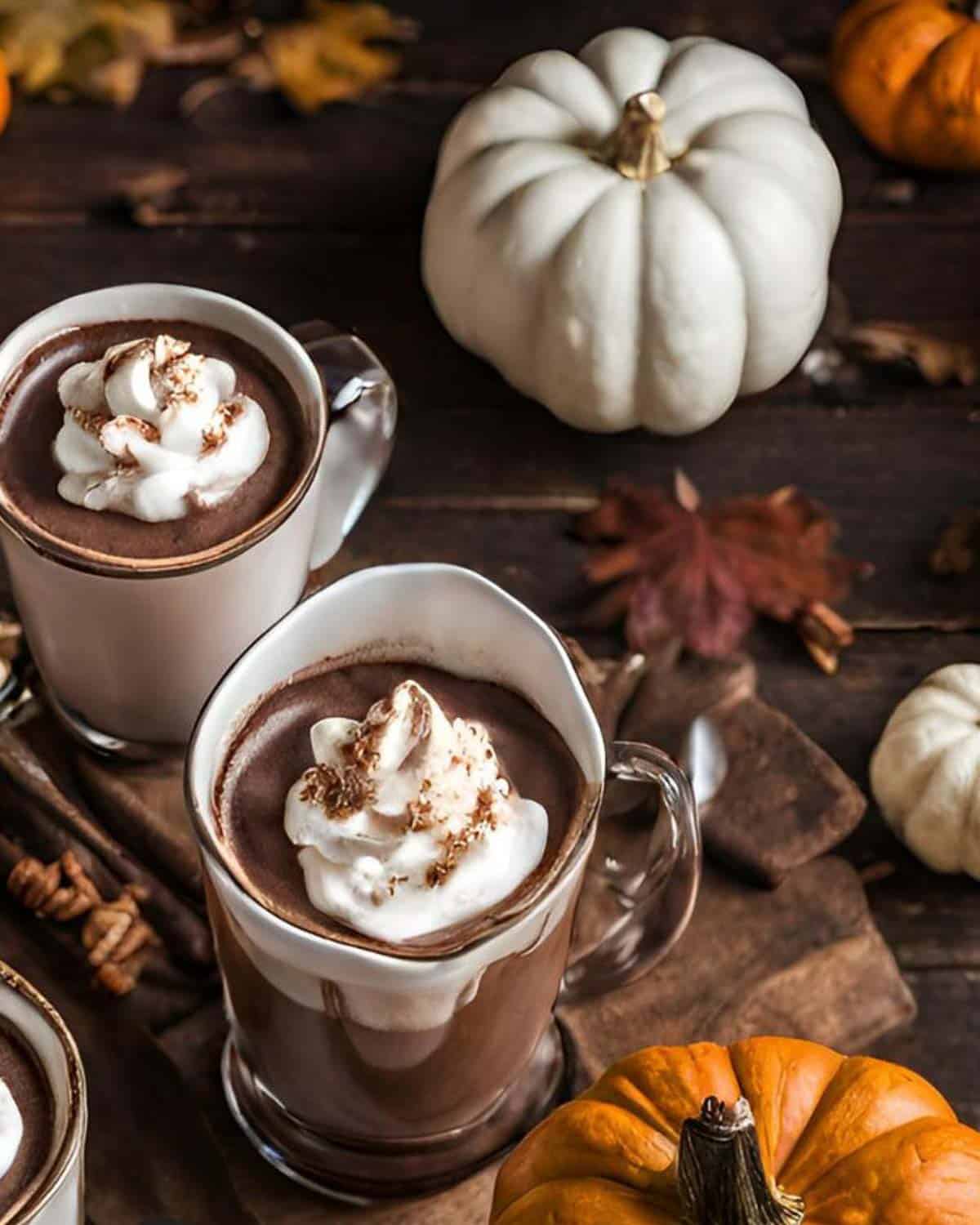 Three mugs of hot chocolate with coconut whipped cream.