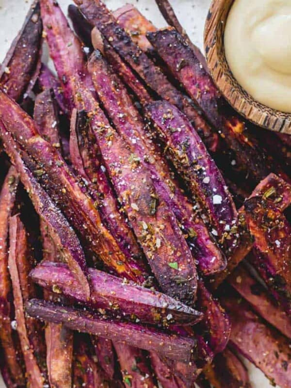 Purple sweet potato fries on a plate with a dip.