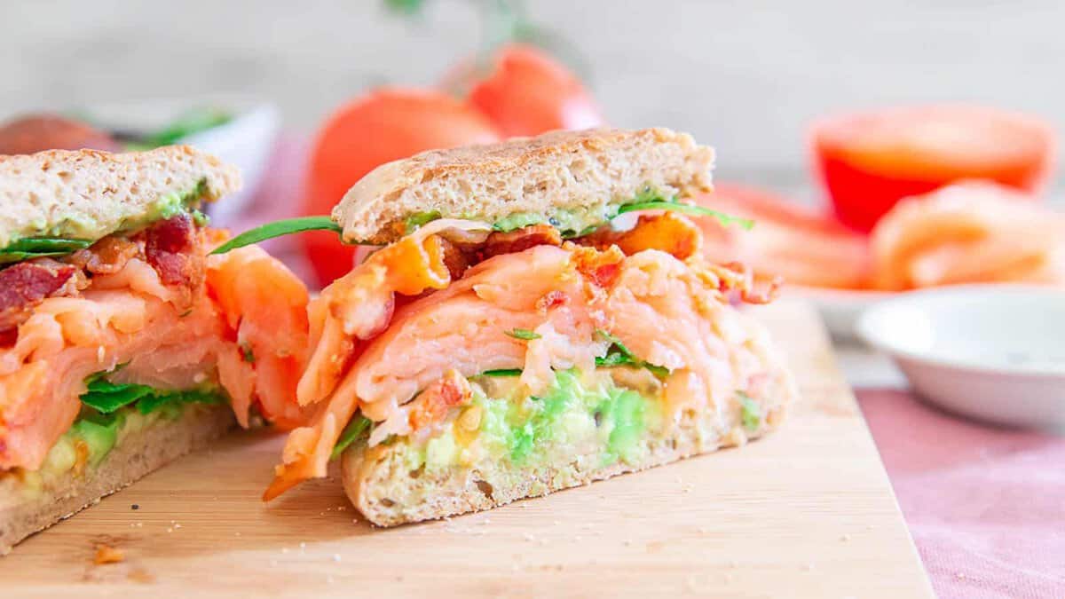 Salmon BLT with avocado on an English muffin.