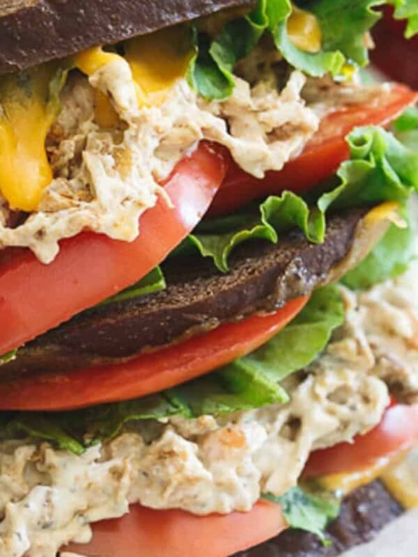 A sandwich with chicken salad, tomatoes and lettuce.