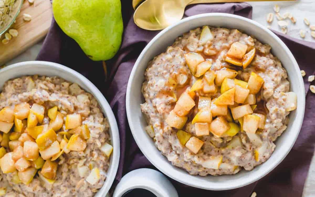 Spiced pear oatmeal in bowls with caramelized chopped pears.