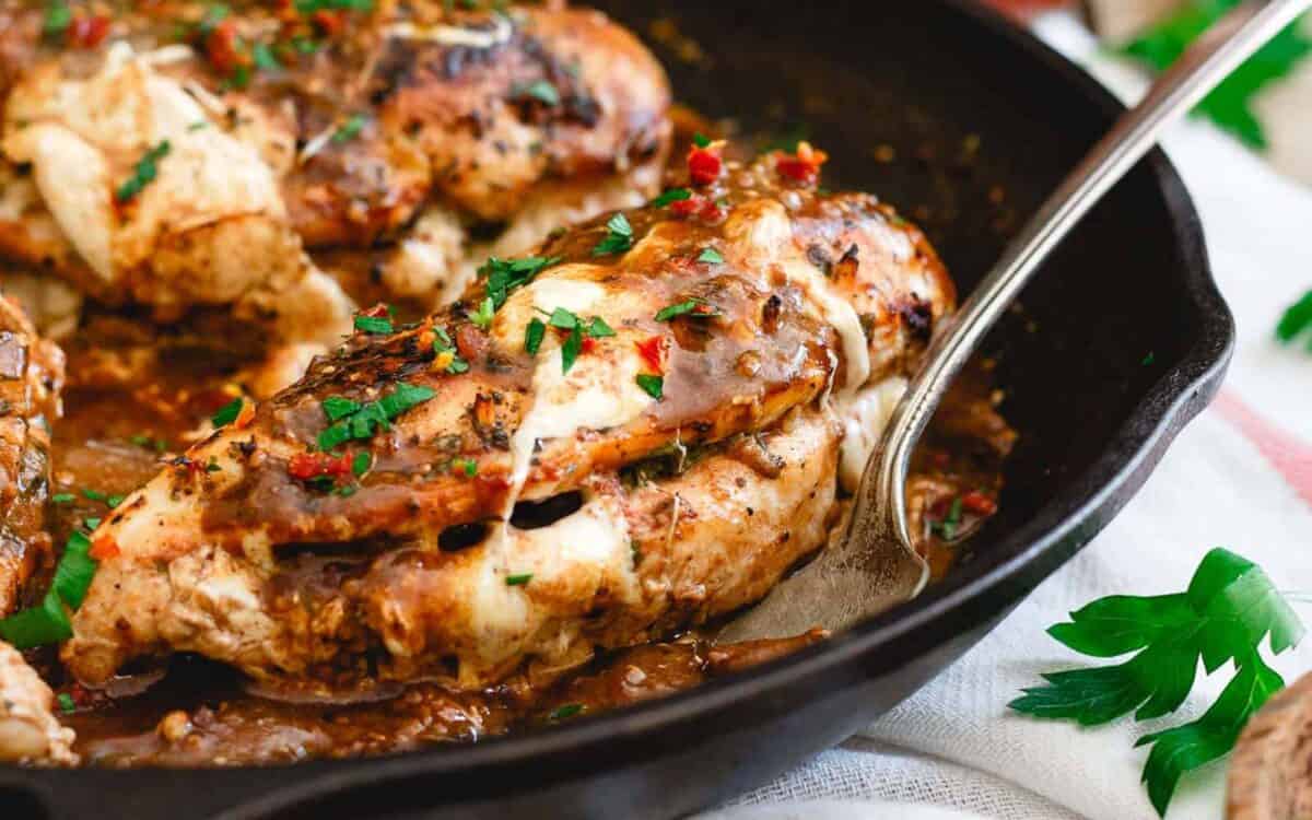 Chicken marsala in a skillet with sauce and herbs.