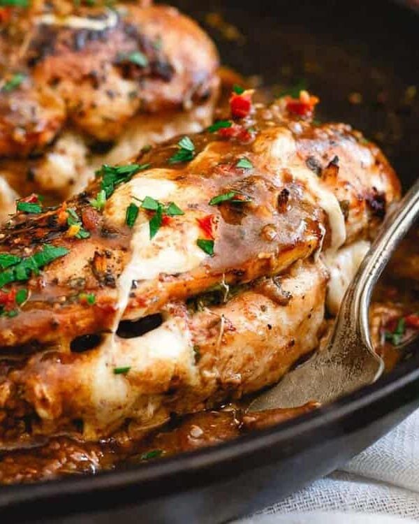 Chicken marsala in a skillet with sauce and herbs.