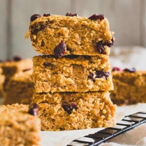 A stack of oatmeal bars with cranberries on top.