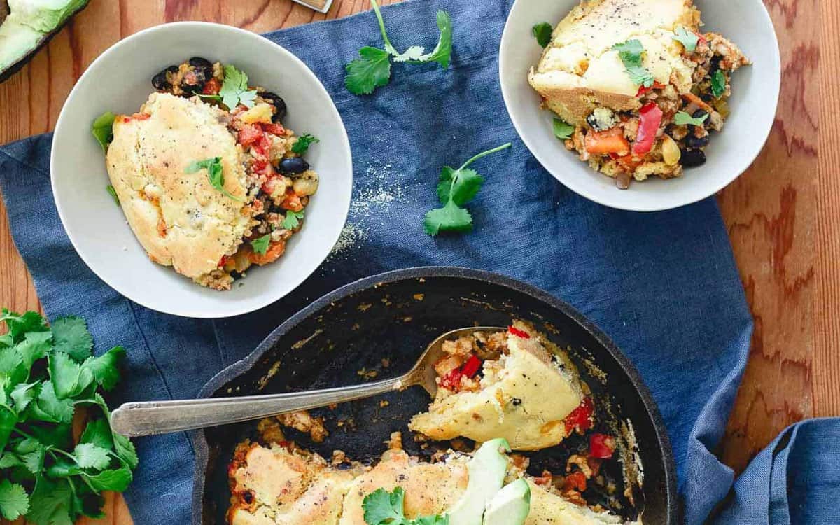 Turkey chili pie in a skillet and serving bowls.