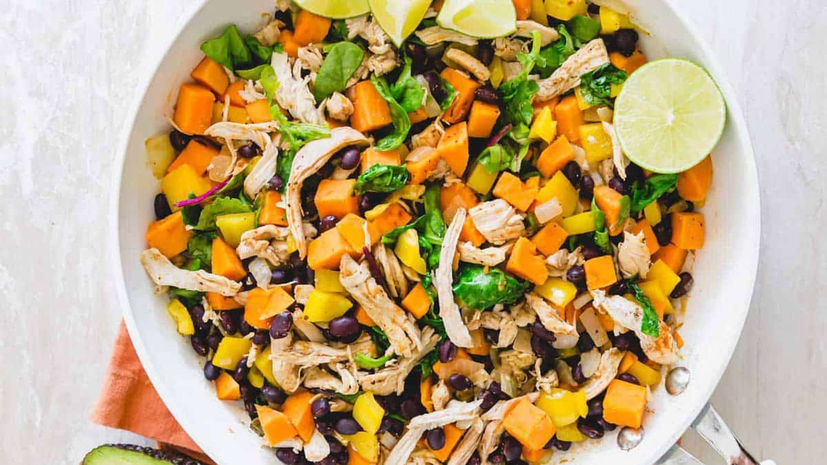 Shredded turkey with sweet potatoes and black beans in a skillet.