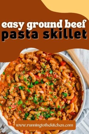 A skillet filled with pasta and a wooden spoon.