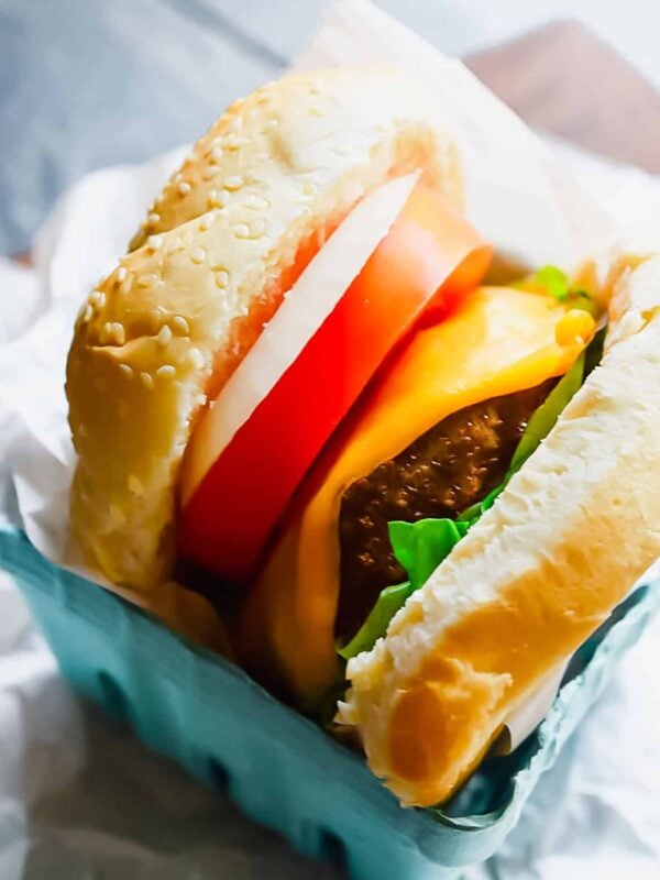 Turkey burger with fixings wrapped in parchment paper.