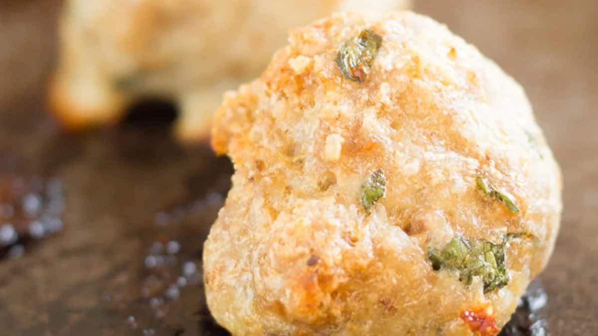 A close up of meatballs on a baking sheet.