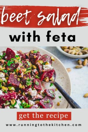 Beet salad with feta on a white plate with a spoon.