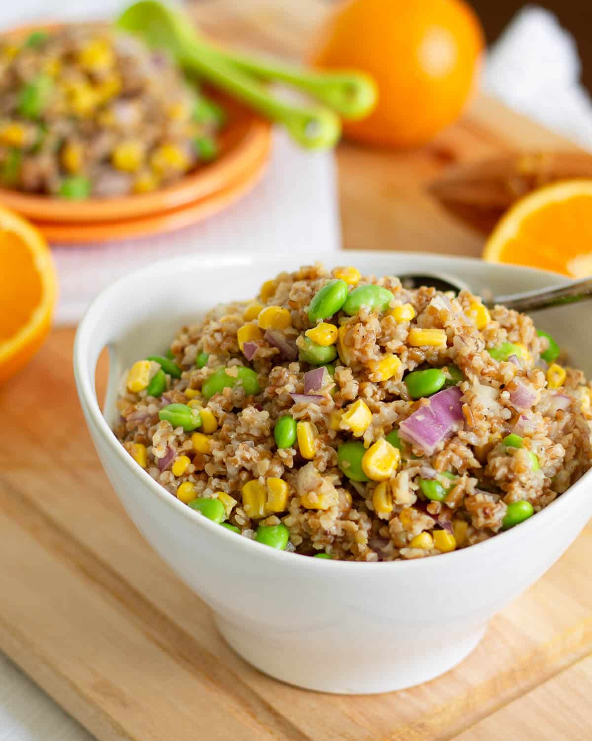 Bulgur salad in a white bowl with orange dressing.