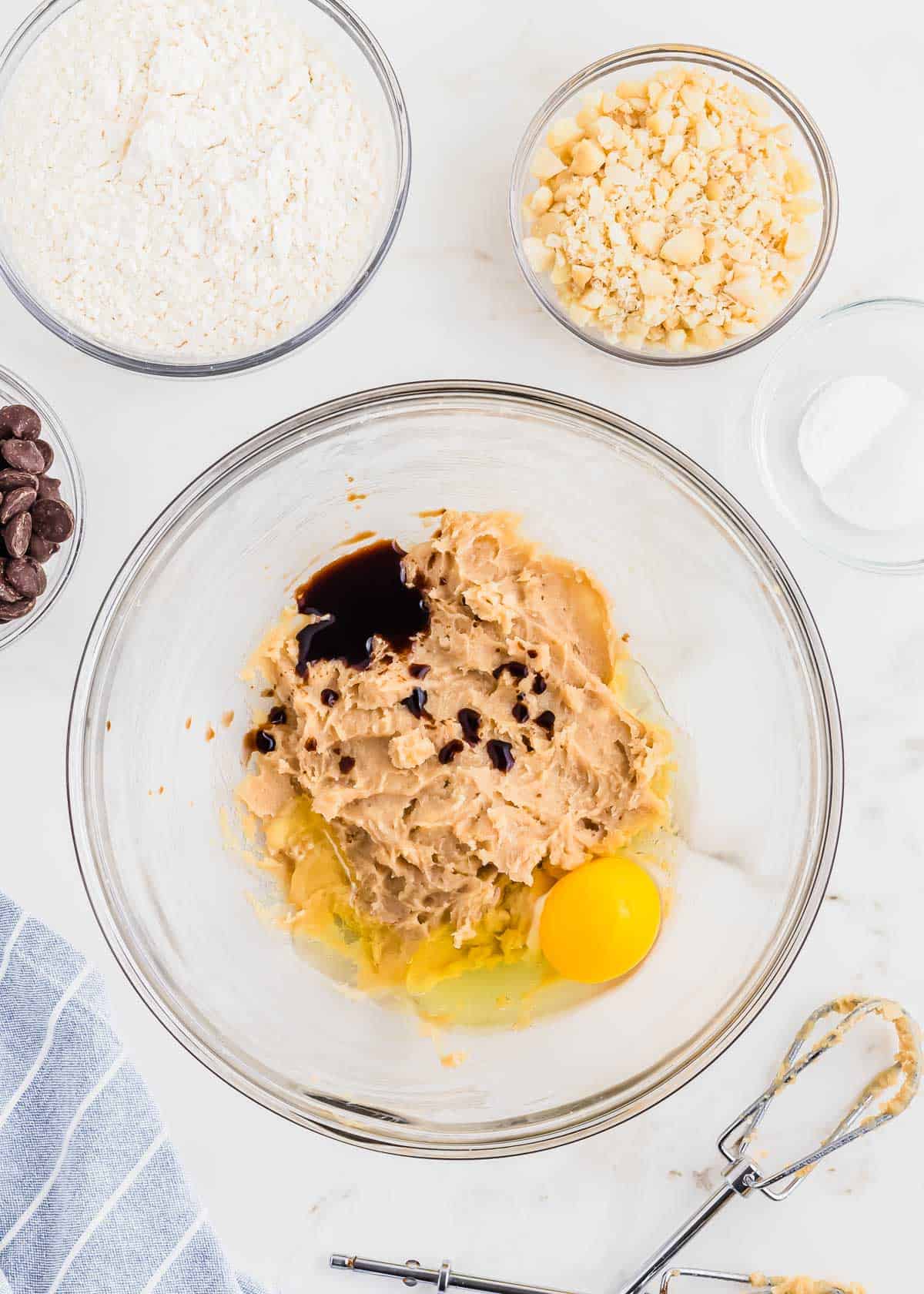 Ingredients to make a chocolate chip macadamia nut cookie recipe in glass bowls.