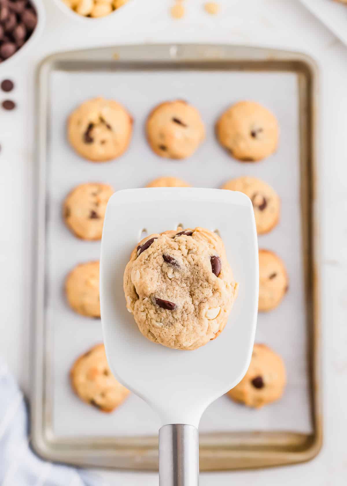 A chocolate chip macadamia nut cookie on a rubber spatula.