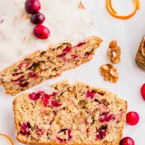 One slice of a cranberry orange bread recipe on a white platter.