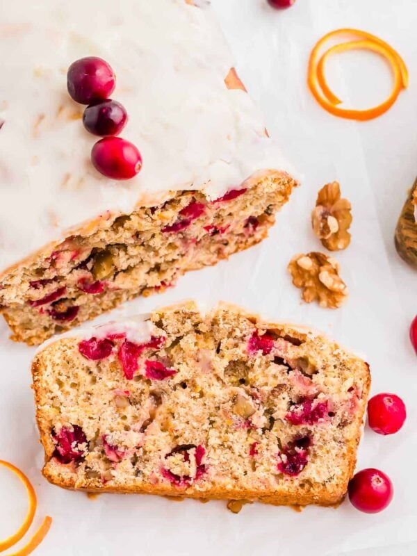 One slice of a cranberry orange bread recipe on a white platter.