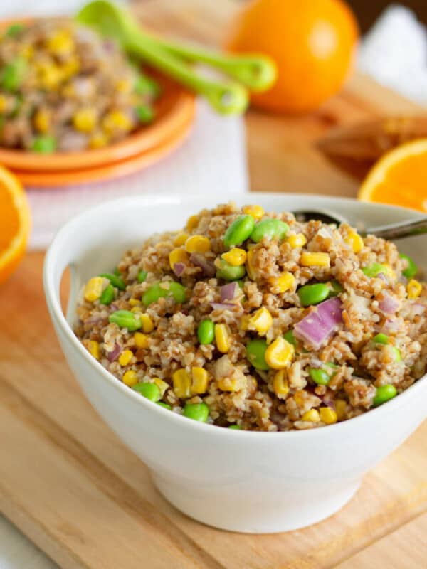 Quinoa salad with peas and oranges in a bowl.