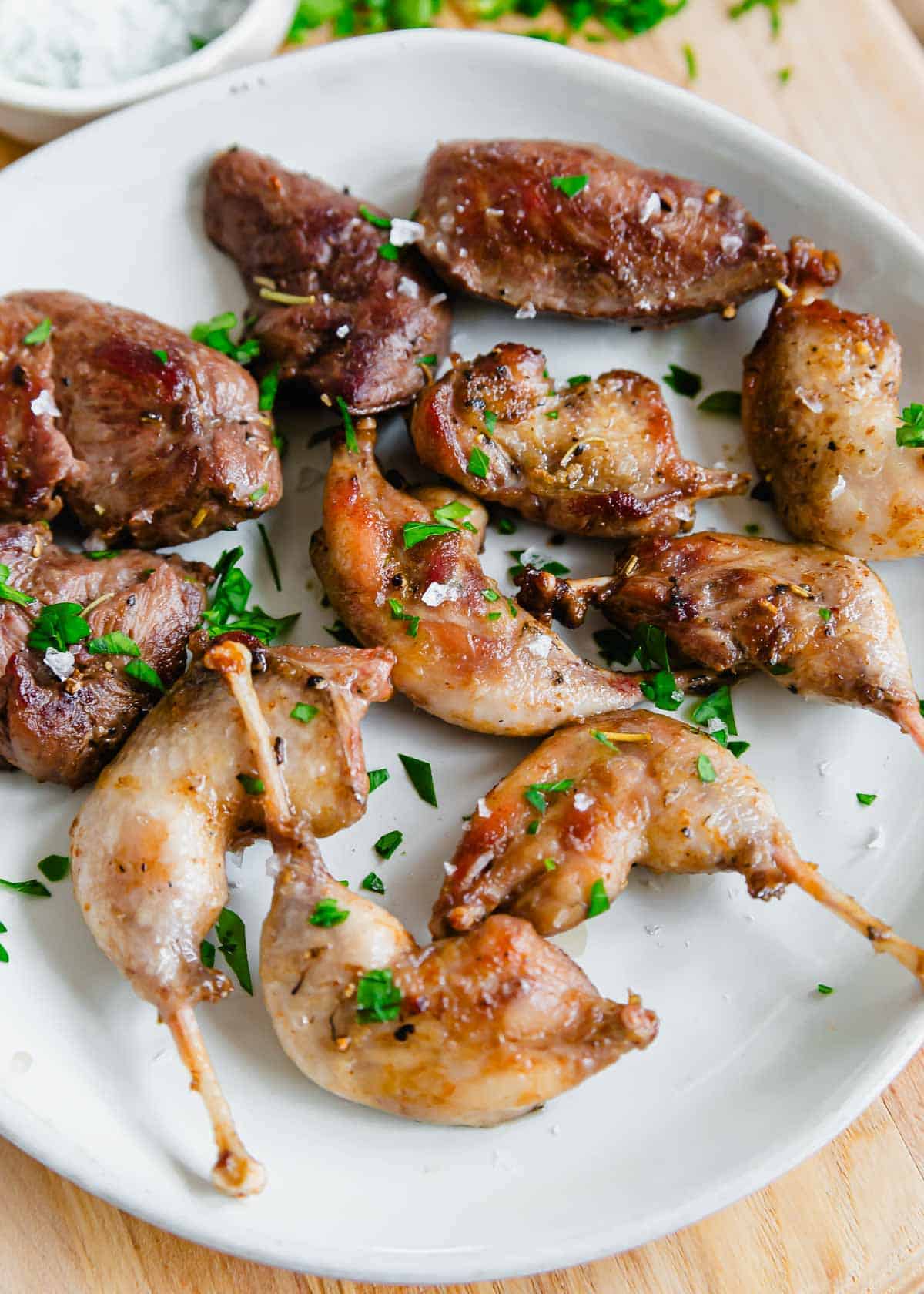 Timberdoodle pan-fried legs and breasts on a plate with salt and parsley.