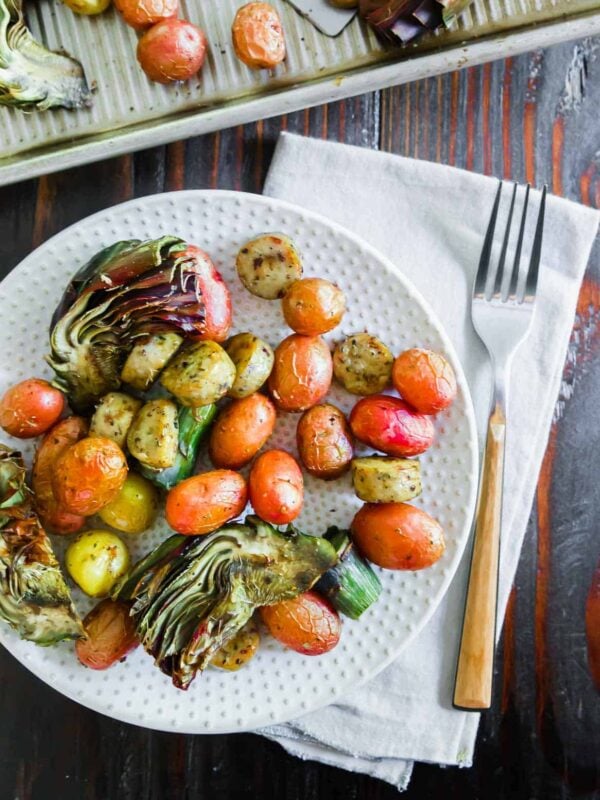 Roasted vegetables and potatoes on a plate with a fork.