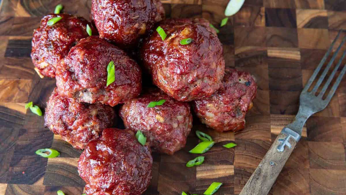 Meatballs on a wooden cutting board.