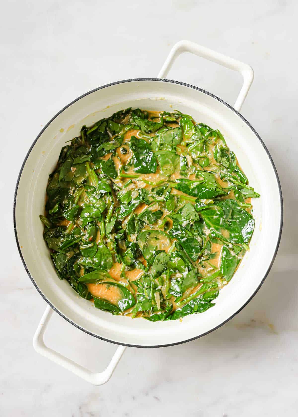 Spinach frittata mixture in a white baking dish.