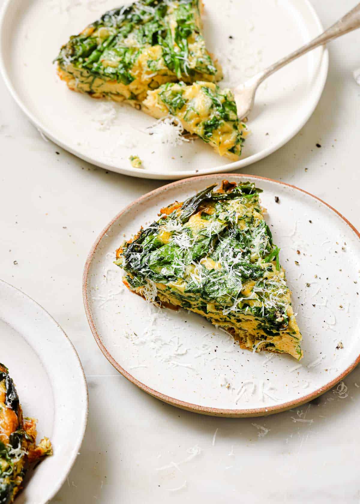 Slices of a baby spinach frittata on plates.
